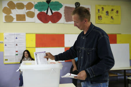 A man casts his ballot during presidential and parliamentary elections at a polling centre in a school in Babino near Zenica, Bosnia and Herzegovina October 7, 2018. REUTERS/Dado Ruvic