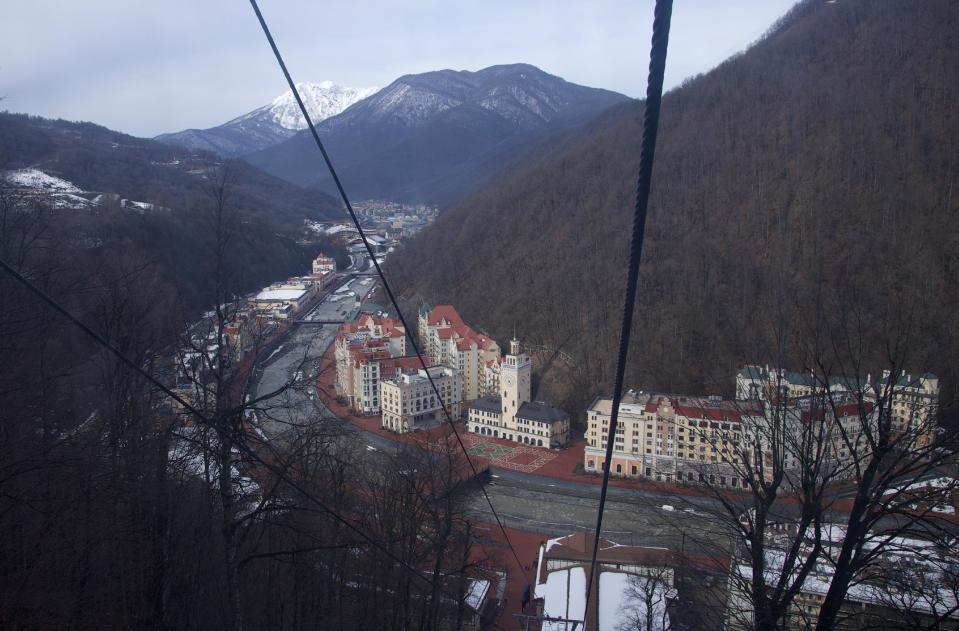 FILE - In this Feb. 6, 2013, file photo, the Rosa Khutor and Esto-Sadok resorts are seen from a cableway cabin, in Rosa Khutor, some 60 km east of the Black Sea resort of Sochi, Russia. For visitors to the Winter Olympics, Sochi may feel like a landscape from a dream. Palm trees evoke a tropical seaside resort, but the Black Sea itself is seriously cold; turn away from the palms and the jagged, snow-covered peaks of the Caucasus Mountains rise nearby. (AP Photo/Ivan Sekretarev, file)