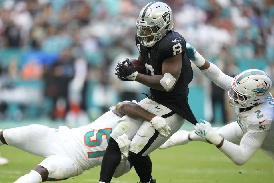 Miami Dolphins linebackers David Long Jr. (51) and Bradley Chubb (2) tackle Las Vegas Raiders running back Josh Jacobs (8) during the second half of an NFL football game, Sunday, Nov. 19, 2023, in Miami Gardens, Fla. (AP Photo/Rebecca Blackwell)