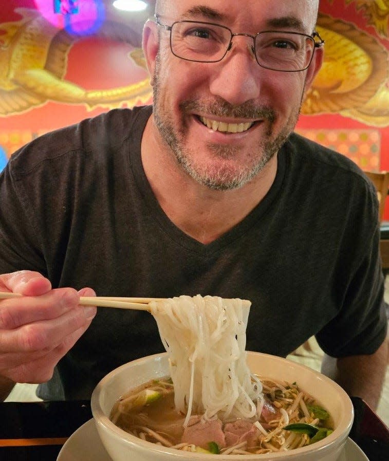 Wade Tatangelo enjoys a bowl of pho, with flank steak and rare steak, at Demi's Noodle House in Palmetto on Jan. 18, 2024.