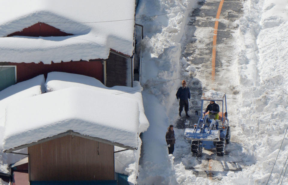 Residents use a snowplow to remove snow from a road in Minamimakimura, Gunma prefecture, near Tokyo, Sunday, Feb. 16, 2014. The second heavy snowfall this month has hit eastern Japan, killing more than 10 people and injuring hundreds, while paralyzing traffic and causing power outages. Japan's weather agency said Sunday that the low pressure system was traveling north, dumping more snow to the area after passing the Tokyo region. (AP Photo/Kyodo News) JAPAN OUT, CREDIT MANDATORY