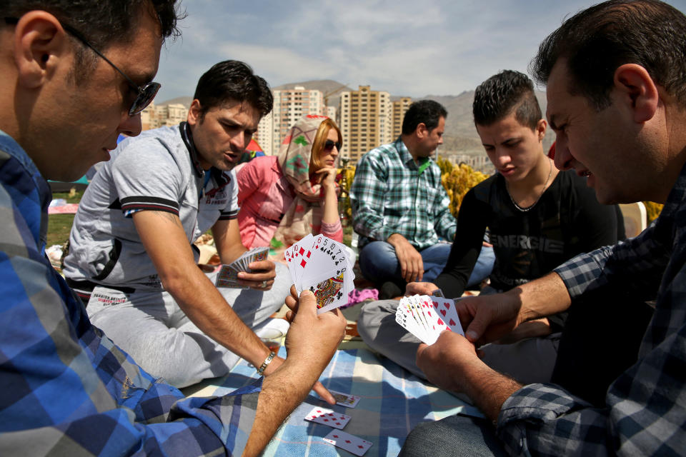 Iranians play cards while observing the ancient festival of Sizdeh Bedar, an annual public picnic day on the 13th day of the Iranian new year, west of Tehran, Iran, Wednesday, April 2, 2014. Sizdeh Bedar, which comes from the Farsi words for “thirteen” and “day out,” is a legacy from Iran’s pre-Islamic past that hard-liners in the Islamic Republic never managed to erase from calendars. Many say it’s bad luck to stay indoors for the holiday. (AP Photo/Ebrahim Noroozi)