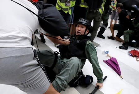 A pro-democracy activist scuffles with a police officer after a march at Sha Tin District of East New Territories, Hong Kong