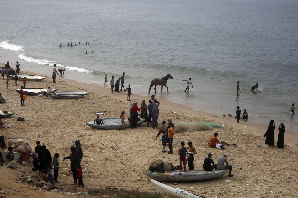 Palestinians resort to the sea water to bathe and clean their tools and clothes due the continuing water shortage in the Gaza Strip, on the beach of Deir al-Balah, Central Gaza Strip, Sunday, Oct. 29, 2023. (AP Photo/Mohammed Dahman)