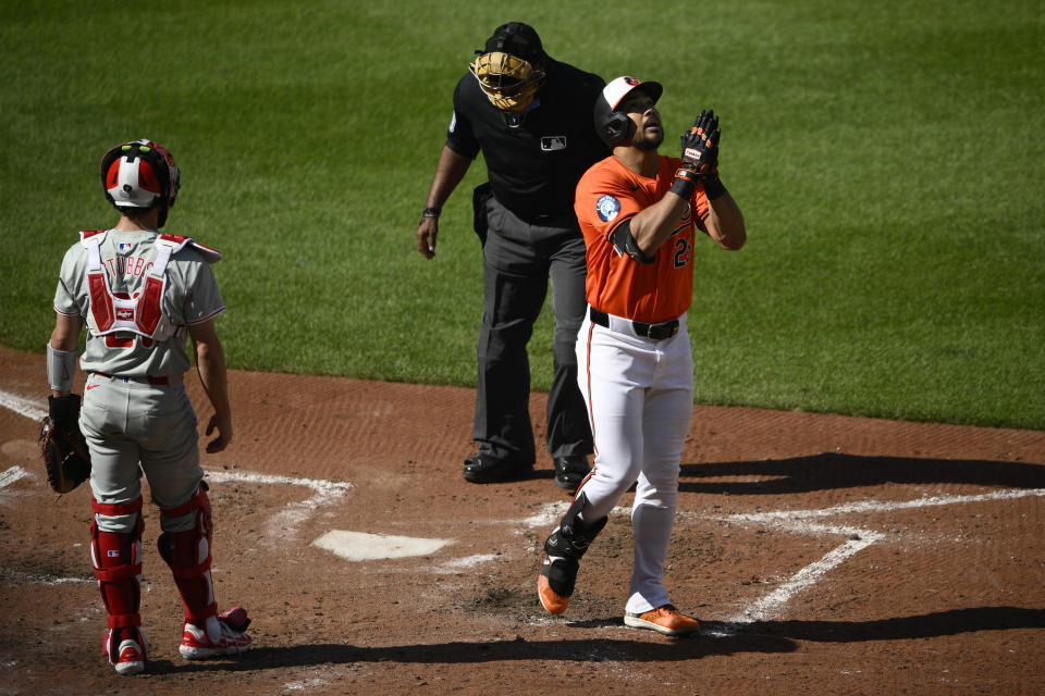 Baltimore Orioles' Anthony Santander, right, celebrates his home run past Philadelphia Phillies catcher Garrett Stubbs, left, and home plate umpire Laz Diaz, center, during the fourth inning of a baseball game, Saturday, June 15, 2024, in Baltimore. (AP Photo/Nick Wass)