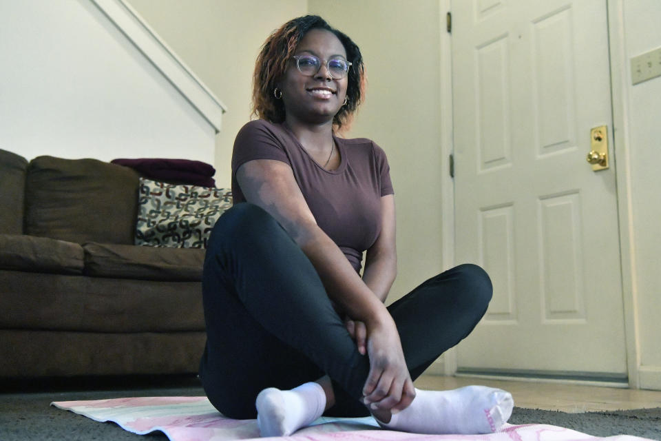 Jalen Matthews, who was diagnosed with sickle cell at birth, stretches on her yoga mat in her home in Louisville, Ky., Monday, Dec. 4, 2023. (AP Photo/Timothy D. Easley)