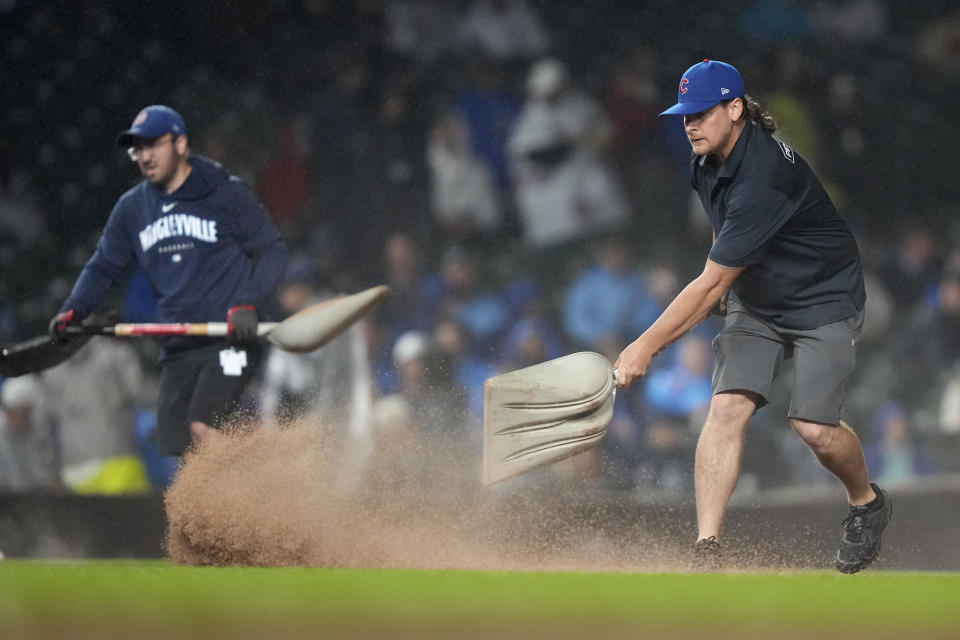 A member of the grounds crew works on the infield during the third inning of a rain-plagued baseball game between the Chicago Cubs and the Cincinnati Reds on Saturday, June 1, 2024, in Chicago. (AP Photo/Charles Rex Arbogast)