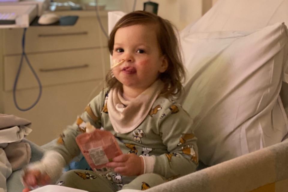 Chloé is pictured sitting in her hospital bed with a tube in her nose. Source: supplied