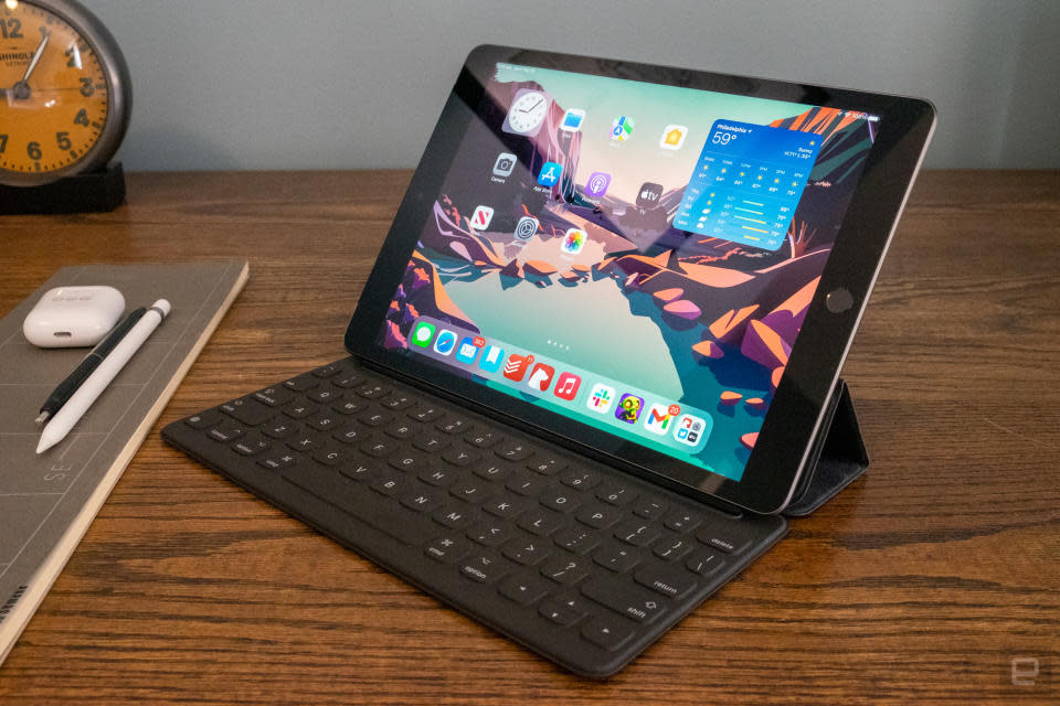 A ninth-generation iPad sits on a table with a keyboard attached.