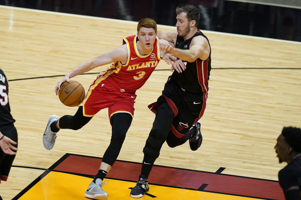 Miami Heat guard Goran Dragic, top right, defends against Atlanta Hawks guard Kevin Huerter (3) during the first half of an NBA basketball game, Sunday, Feb. 28, 2021, in Miami. (AP Photo/Lynne Sladky)