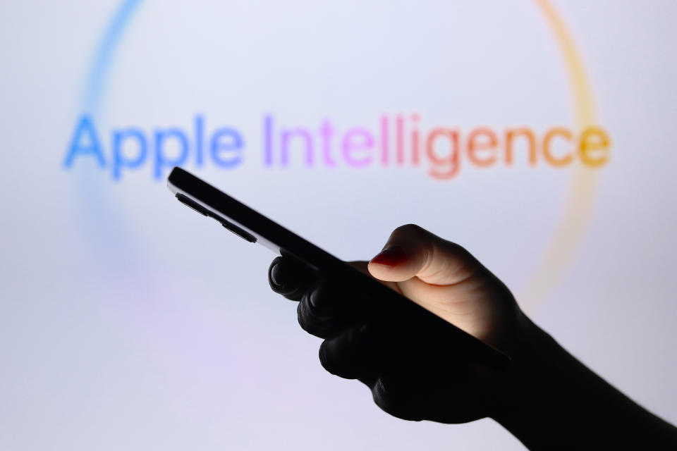 PARAGUAY - 30/07/2024: Dalam ilustrasi foto ini, logo Apple Intelligence terlihat di latar belakang dengan siluet tangan yang memegang ponsel pintar. (Ilustrasi Foto oleh Jaque Silva/SOPA Images/LightRocket via Getty Images)