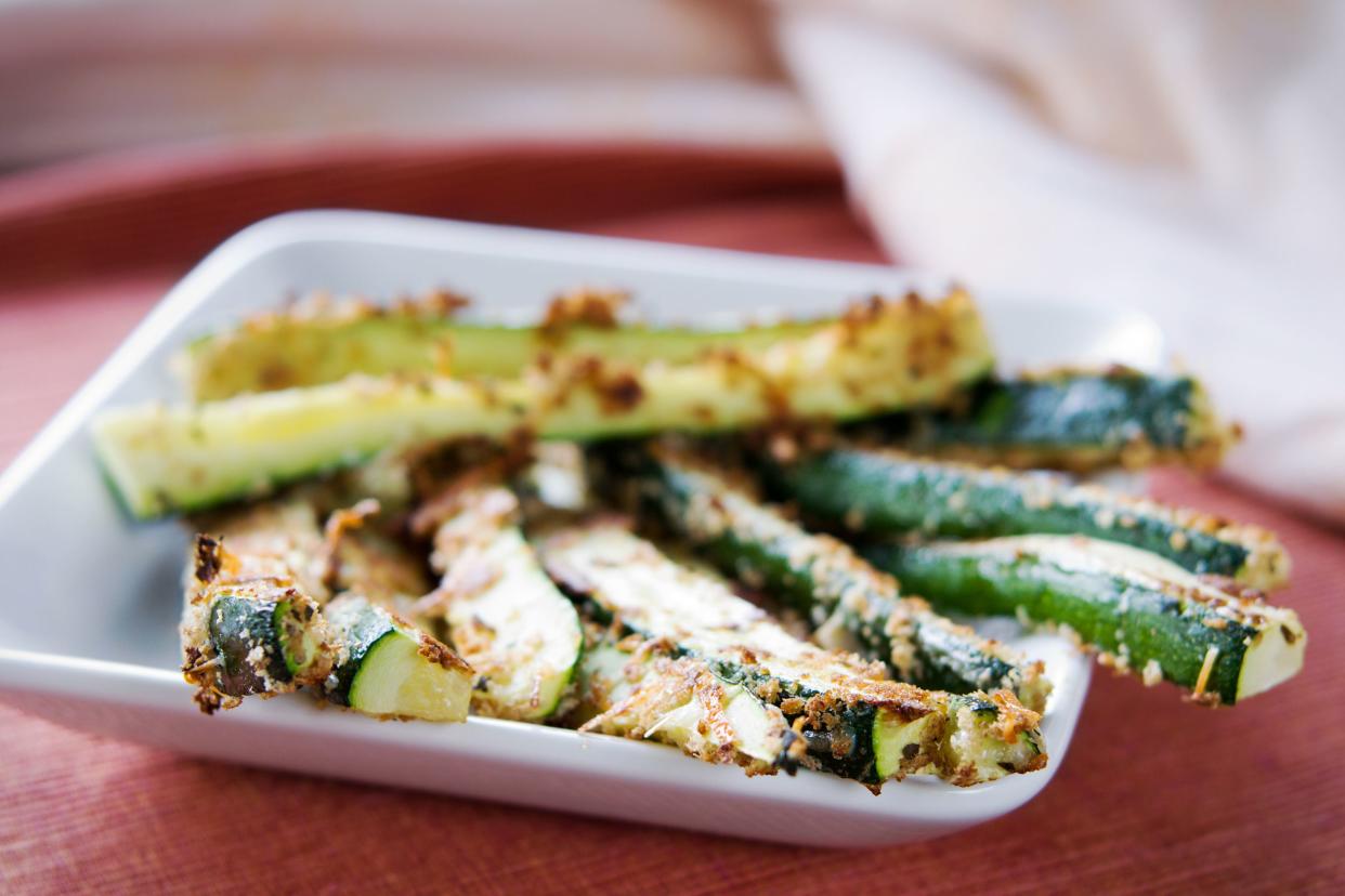 close-up of baked zucchini fries on white plate