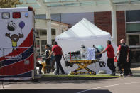 FILE - In this April 9, 2020, file photo, healthcare workers wheeling a gurney into Salem Hospital's emergency room in Salem, Ore., during the coronavirus outbreak. Oregon health officials reported its second-highest tally of confirmed cases of COVID-19 and five additional deaths on Friday, June 26, 2020, the same day that authorities released new modeling that shows increased transmission of the coronavirus since the state began reopening in mid-May. (AP Photo/Andrew Selsky, File)