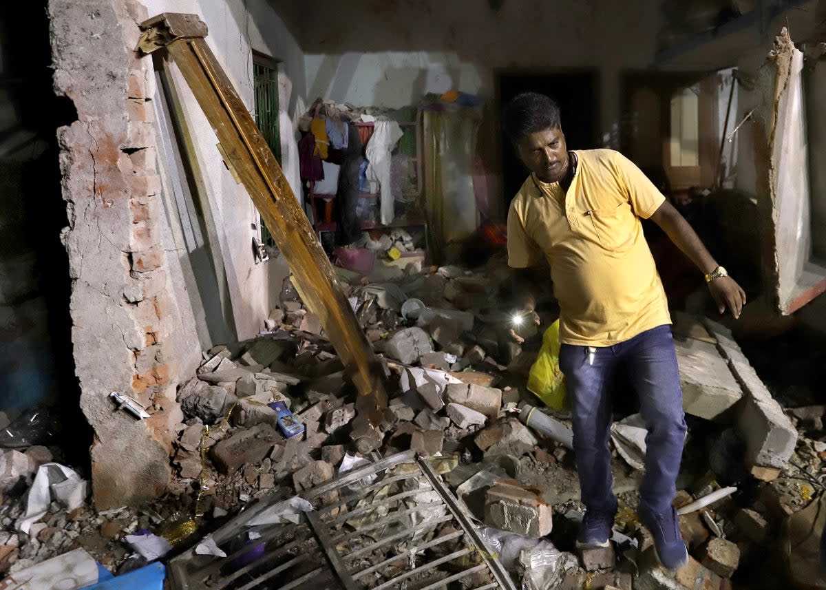 A resident inspects his damaged home after a massive explosion occurred at a firecracker factory in Duttapukur village, east of Kolkata, West Bengal state (EPA)