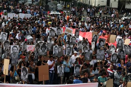 People holding pictures of victims of the guerrilla conflict in the 80s and 90s protest after Peruvian President Pedro Pablo Kuczynski pardoned former President Alberto Fujimori in Lima, Peru, December 25, 2017. REUTERS/Mariana Bazo