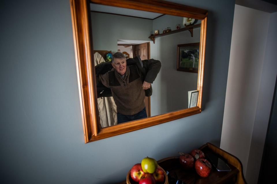 Schwallier's Country Basket owner Philip Schwallier puts his coat on to get the mail after pruning Zestar! apple trees to reduce buds to allow apples to grow larger and for the sun to be able to make high quality apples at his family farm in Sparta on Friday, Jan. 21, 2022. Schwallier lost 40% of his apple crop last year because of a frost event.