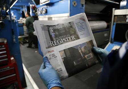 A printer checks one of the first copies of the inaugural Los Angeles Register newspaper as it comes off the presses in Santa Ana, California April 16, 2014. REUTERS/Lucy Nicholson