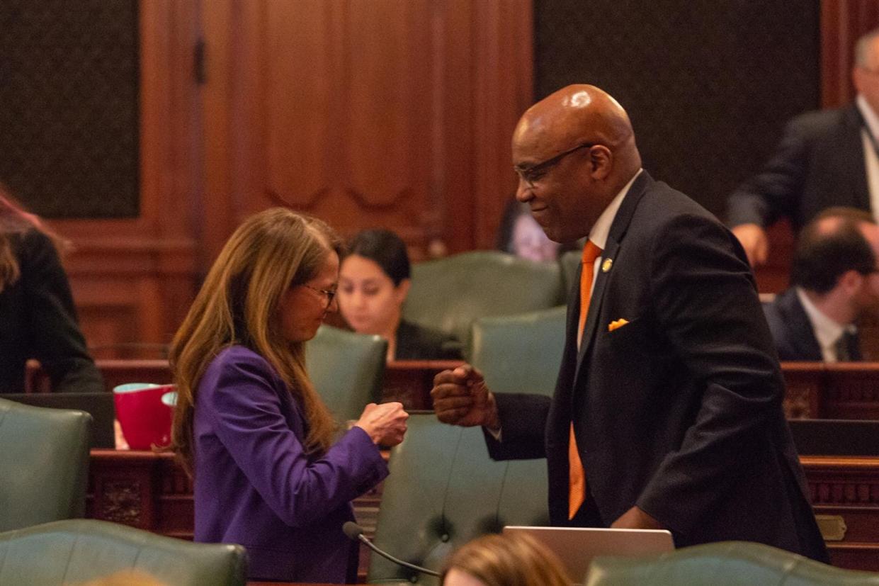 State Rep. Jennifer Gong-Gershowitz, D-Glenview, gets a fist bump Wednesday from Illinois Attorney General Kwame Raoul after she passed a measure giving his office authority to sue gun dealers for deceptive marketing practices