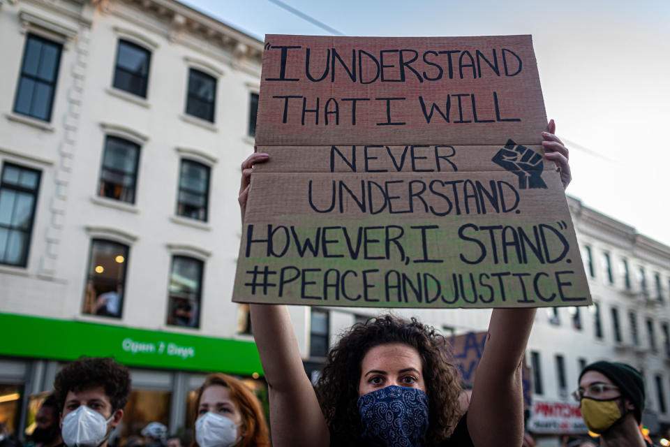 <i>A demonstrator in Brooklyn, New York, calls for justice for George Floyd and other victims of police violence with a sign that reads: "I understand that I will never understand. However, I stand. #peaceandjustice"</i>