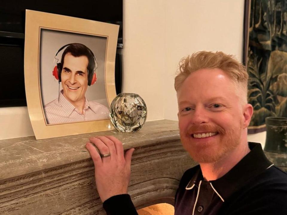 Jesse Tyler Ferguson posing with Ty Burrell’s photo (Instagream)