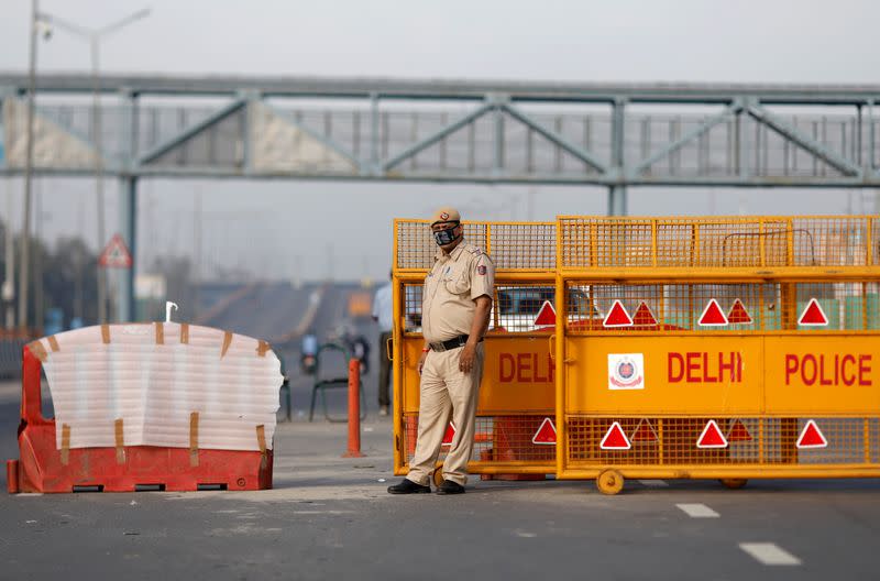 A police officer stands at New Delhi's border barricade during lockdown by the authorities to limit the spreading of coronavirus disease (COVID-19), in New Delhi