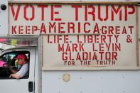 A man drives a truck covered in signs supporting President Trump around the site of the tenth Democratic 2020 presidential debate in Charleston