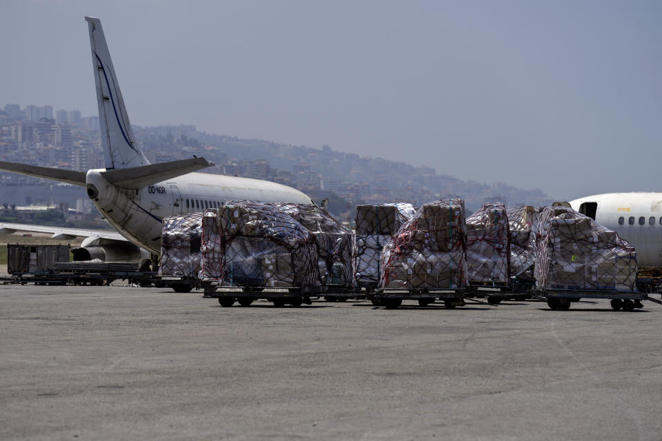 Workers unload a shipment from an airplane during a tour for journalists and diplomats at the Rafik Hariri International Airport in Beirut, Lebanon, Monday, June 24, 2024. The tour comes a day after a British newspaper published a story, citing anonymous airport workers, claiming that Hezbollah is storing weapons at the airport, as monthslong clashes with the Israeli military on the Lebanon-Israel border have significantly escalated in recent weeks. (AP Photo/Bilal Hussein)