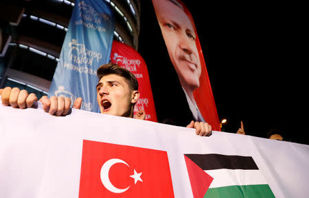 A demonstrator shouts slogans, as a portrait of Turkey's President Tayyip Erdogan is seen in the background, during a protest against the U.S. intention to move its embassy to Jerusalem and to recognise the city of Jerusalem as the capital of Israel, near the U.S. Embassy in Ankara, Turkey, December 6, 2017. REUTERS/Umit Bektas