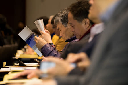 Shareholders look at annual reports during the Samsung Electronics Co. annual general meeting at the company's Seocho office building in Seoul, South Korea, March 23, 2018. SeongJoon Cho/Pool via Reuters