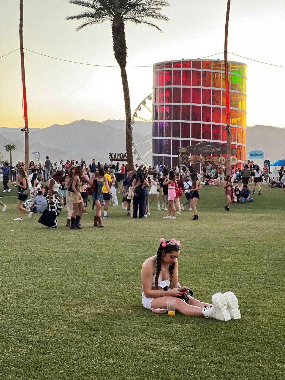 Festivalgoer Jocelyn Leone, of Atlanta, Georgia, sits on the grass between the Gobi tent and Outdoor Theatre on Friday, April 21, 2023.