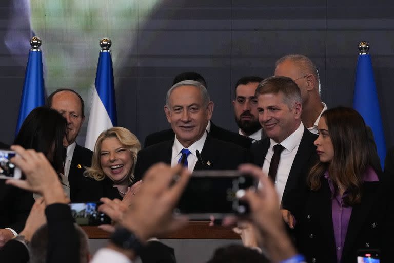 Former Israeli Prime Minister and the head of Likud party, Benjamin Netanyahu, center, and his wife Sara gesture after first exit poll results for the Israeli Parliamentary election at his party's headquarters in Jerusalem, Wednesday, Nov. 2, 2022. (AP Photo/Maya Alleruzzo)