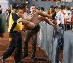 A streaker puts up a struggle as he is taken away during the first half of an NCAA college football game, Saturday, Oct. 9, 2010, in Miami. (AP Photo/Wilfredo Lee)