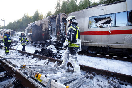 Firefighters work at a destroyed German high speed ICE train after it caught fire on the way from Cologne to Frankfurt in Dierdorf, Germany, October 12, 2018. REUTERS/Wolfgang Rattay