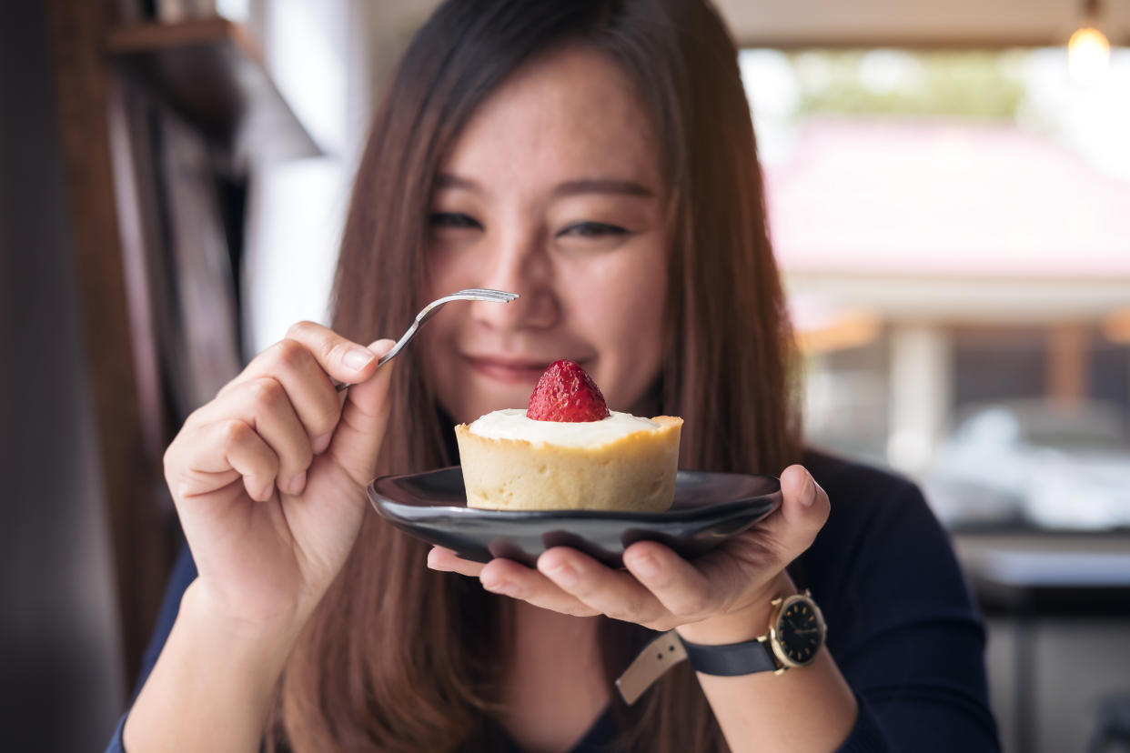 Close-Up Of Woman Eating Sweet Food In Plate At Home