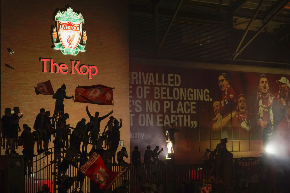 Fans climbed atop the famous Shankly gates outside Anfield to revel in their Premier League title win.