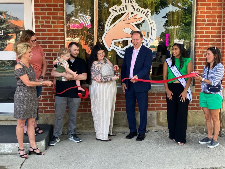 Rebekah Elliott cuts the ribbon at a ceremony Friday for the Nail Nook in Shelby.