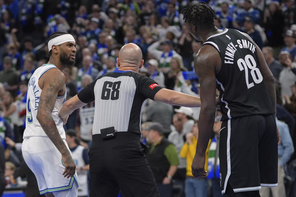 Referee Jacyn Goble holds back Minnesota Timberwolves guard Nickeil Alexander-Walker (9) and Brooklyn Nets forward Dorian Finney-Smith (28) following an altercation during the second half of an NBA basketball game Saturday, Feb. 24, 2024, in Minneapolis. (AP Photo/Abbie Parr)