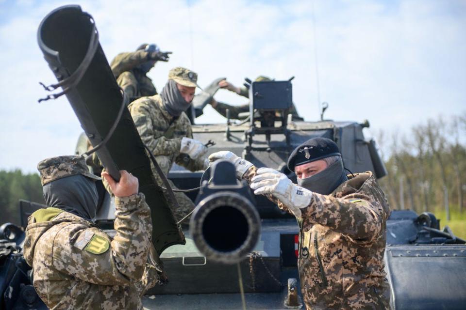 Ukrainian soldiers work on the tank gun of a Leopard 1 A5 main battle tank