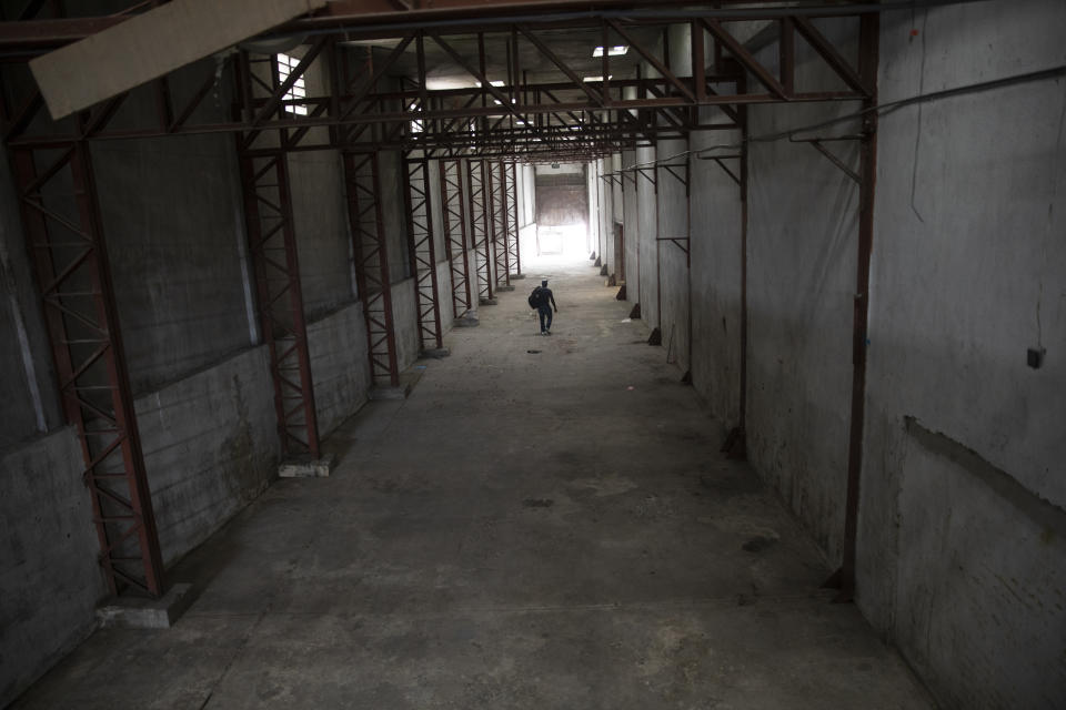 Un trabajador camina por un almacén vacío propiedad de Marche Titony, en Puerto Príncipe, Haití, el 21 de septiembre de 2021. El almacén fue saqueado por pandillas el 16 de junio. (AP Foto/Rodrigo Abd)