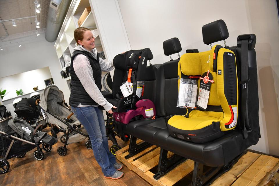 St. Cloud location general manager Amy Serbus demonstrates the car seat display, complete with a real car seat, Tuesday, April 26, 2022, at Baby's on Broadway in downtown St. Cloud.