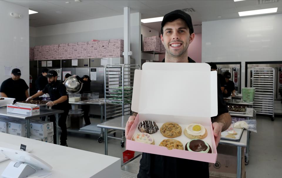 Seth Neeleman, the owner, holds a sampling of cookies including clockwise from top left: Cookies & Cream, Milk Chocolate Chip, Sugar (Gold Coin), Mint Brownie, Butterscotch Chip and Mallow Creme at  Crumbl Cookies on North Central Avenue in Hartsdale, photographed March 15, 2023. 