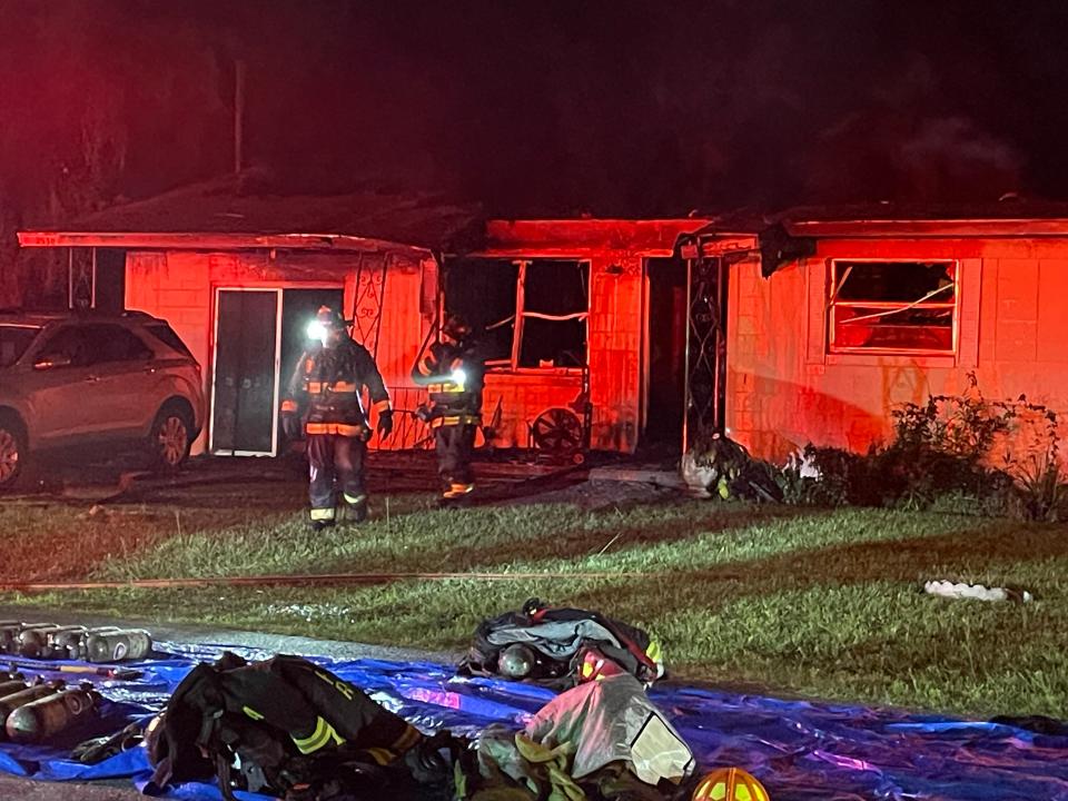 Ocala firefighters exiting a home where a woman died on Thursday night