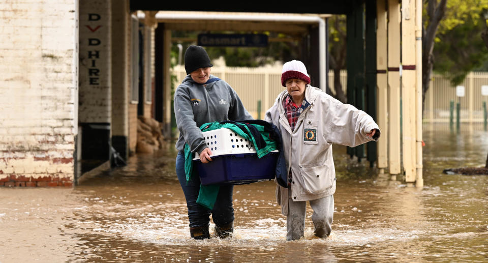 People wade through flood waters after a deluge of rain.