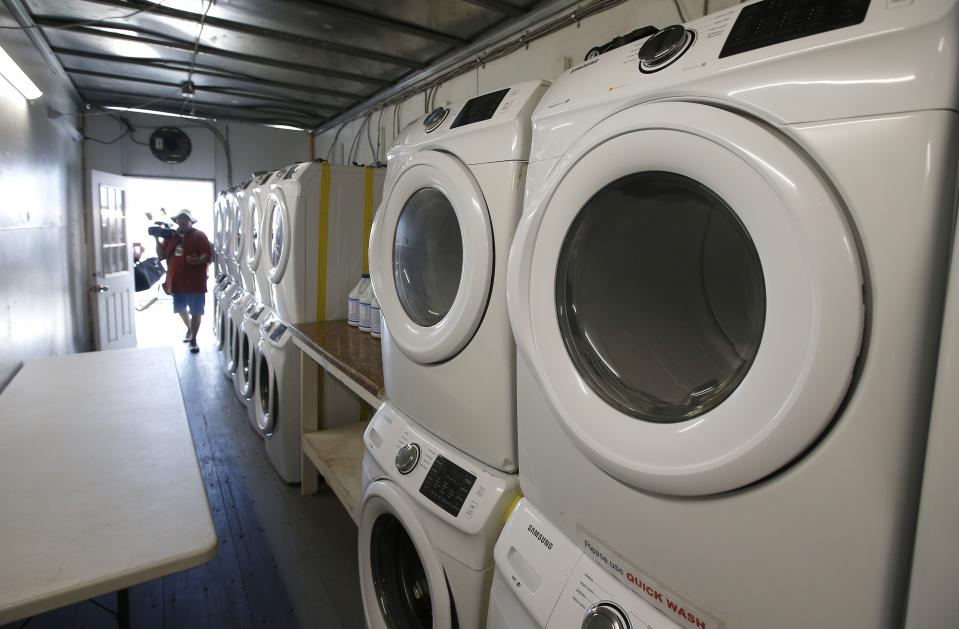 Laundry machines line a room as the U.S. Border Patrol unveiled a new 500-person tent facility during a media tour Friday, June 28, 2019, in Yuma, Ariz. The facility will be used to process detained immigrant children and families who cross the U.S. border. The Border Patrol says it will start placing families there on Friday night. (AP Photo/Ross D. Franklin)