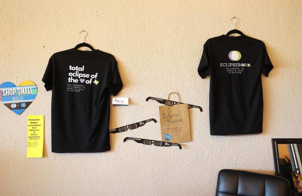 T-shirts and eclipse glasses for sale are displayed on the wall of Finished Seams boutique in downtown Hillsboro on Thursday, February 22, 2024.