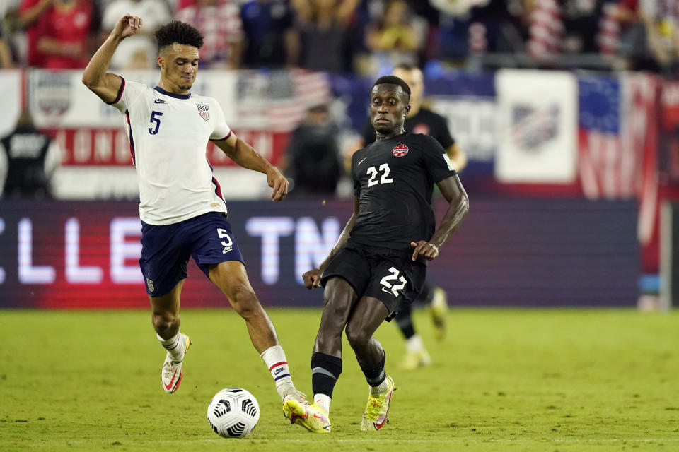 United States defender Antonee Robinson (5) and Canada defender Richie Laryea (22) battle for the ball during the second half of a World Cup soccer qualifier Sunday, Sept. 5, 2021, in Nashville, Tenn. (AP Photo/Mark Humphrey)