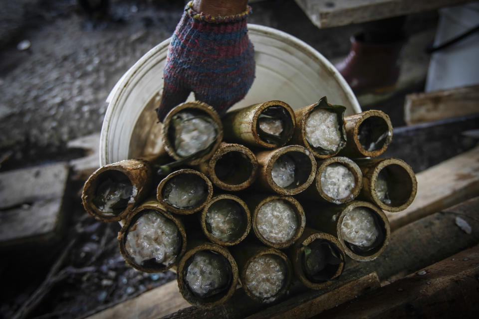 FILE - A Malaysian Muslim vendor arranges cooked lemang, glutinous rice stuffed in bamboo sticks and cooked over a charcoal fire, ahead of the Eid Al-Fitr celebrations in Kuala Lumpur, Malaysia, on July 15, 2015. Malaysia's government said Monday, Oct. 2, 2023, the country that enough rice is available and urged people not to hoard locally produced rice after recent panic-buying led to empty shelves in supermarkets and grocery stores nationwide. (AP Photo/Joshua Paul, File)