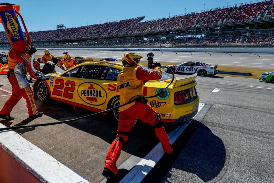 The pit crew for Joey Logano run to the car during a pit stop during a NASCAR Cup Series auto race Sunday, Oct. 2, 2022, in Talladega, Ala. (AP Photo/Butch Dill)