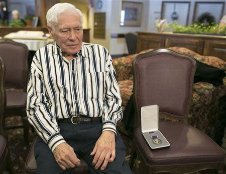 World War II veteran Richard "Dick" Faulkner sits beside his Purple Heart medal after being honored in Auburn, New York March 8, 2014. REUTERS/Mike Bradley