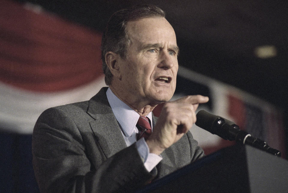 FILE - President George H. W. Bush gestures while formally launching his re-election campaign in Washington, Feb. 12, 1992. The president told a cheering crowd, "I want to serve as your president four more years." (AP Photo/Dennis Cook, File)